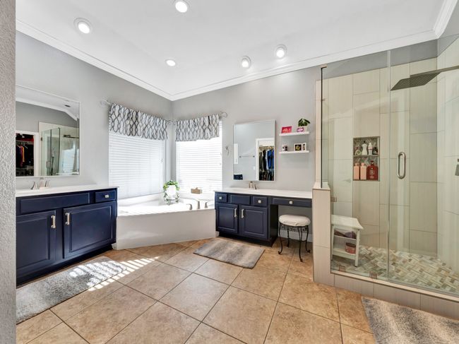 Bathroom featuring crown molding, a sink, jetted tub, and a shower | Image 24
