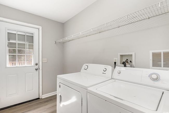 Washroom featuring washing machine and dryer, visible vents, baseboards, light wood-type flooring, and laundry area | Image 22