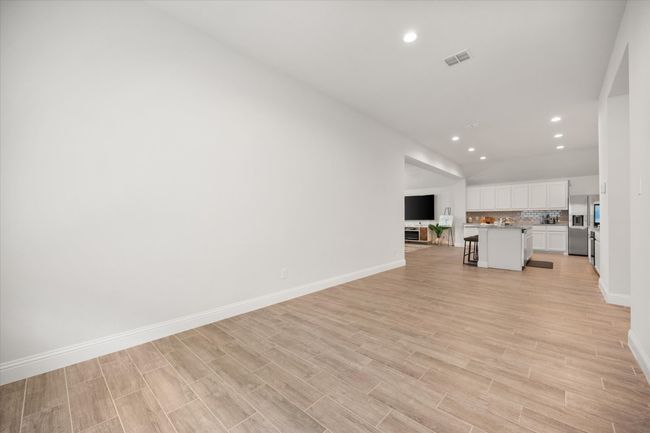 Unfurnished living room with vaulted ceiling, light wood finished floors, and recessed lighting | Image 23