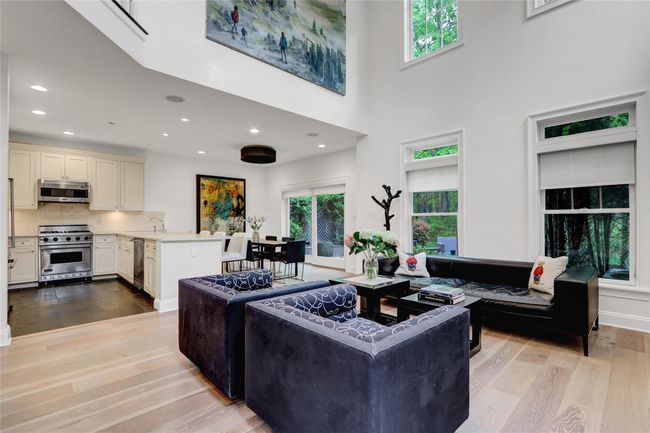 Living room featuring light wood-type flooring, recessed lighting, and a towering ceiling | Image 4