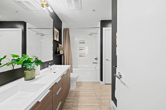 Full bath featuring a sink, double vanity, shower / tub combo with curtain, and toilet | Image 17