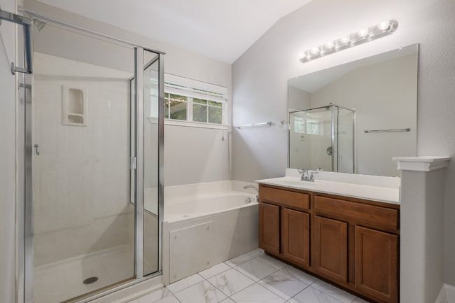 Bathroom featuring a shower stall, a jetted tub, vanity, and tile flooring | Image 13