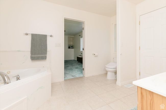 Bathroom featuring a jetted tub, vanity, and tile patterned flooring | Image 33