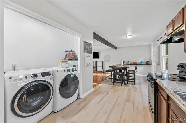 Washroom with baseboards, washing machine and clothes dryer, and light wood-type flooring | Image 18