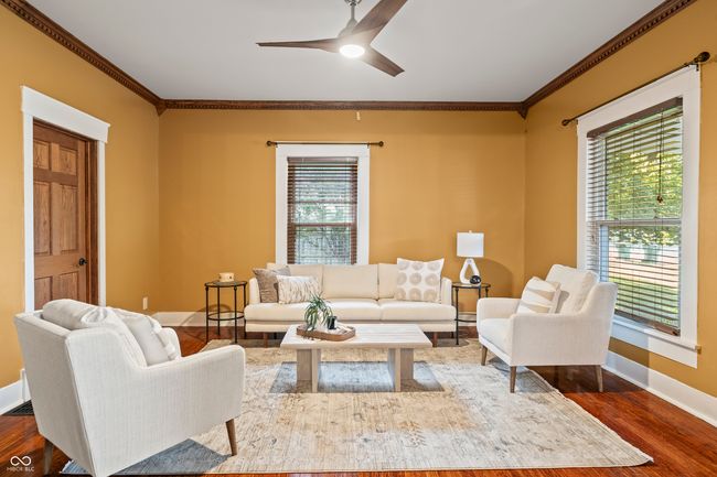 living area with crown molding, dark wood-style flooring, and ceiling fan | Image 7