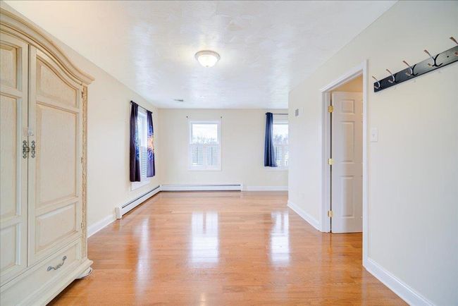 Unfurnished room featuring baseboards, light wood-style floors, and baseboard heating | Image 18