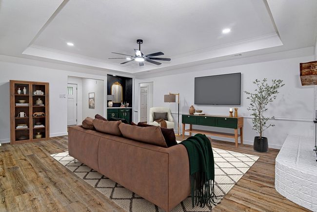 Living area with a tray ceiling, wood finished floors, a ceiling fan, ornamental molding, and recessed lighting | Image 8