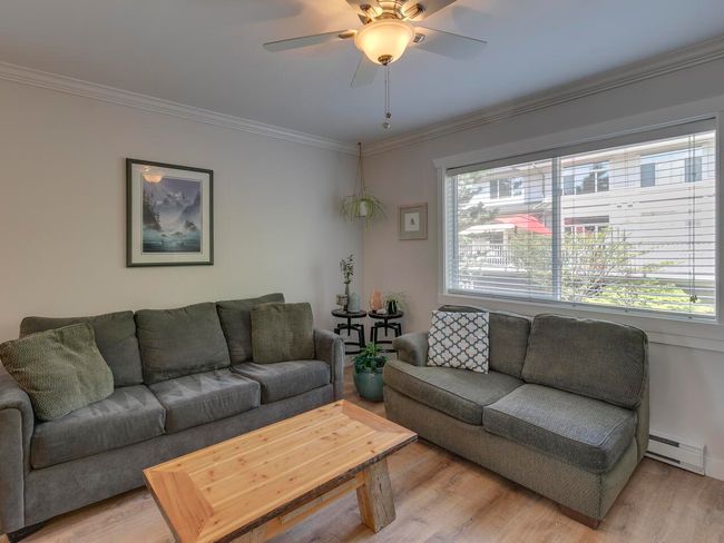 Living room featuring light wood-type flooring, crown molding, baseboard heating, and a ceiling fan | Image 11