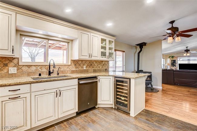 Kitchen with dishwasher, wine cooler, a ceiling fan, light wood-style floors, and recessed lighting | Image 4