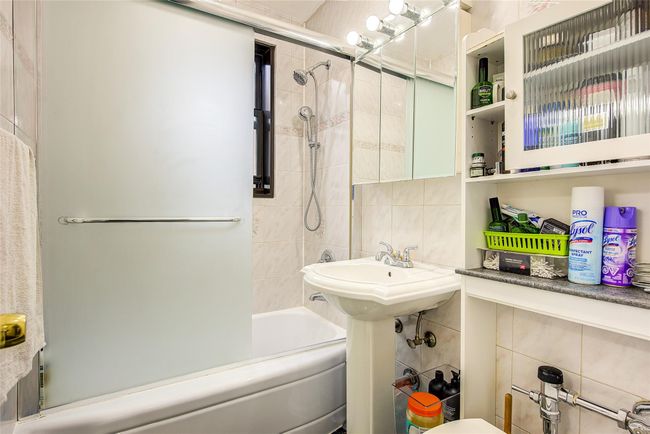 Bathroom with tile walls, bathtub / shower combination, and decorative backsplash | Image 17