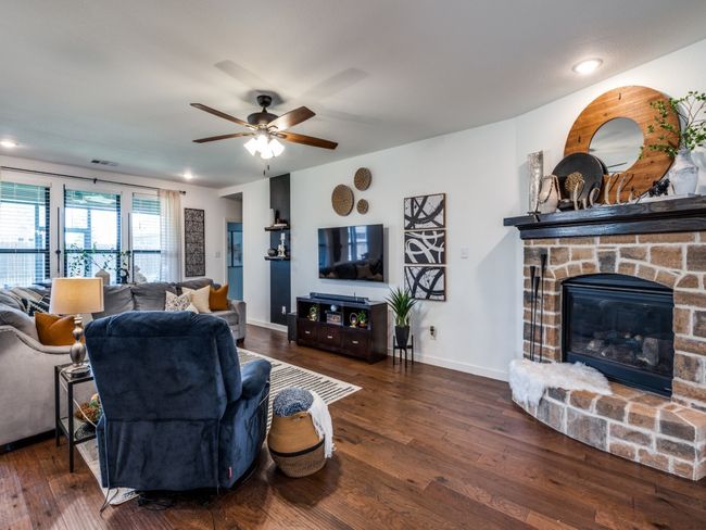 Living room featuring a fireplace, wood finished floors, visible vents, and a ceiling fan | Image 5