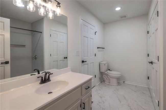 Bathroom featuring vanity, marble finish flooring, a shower, and recessed lighting | Image 13