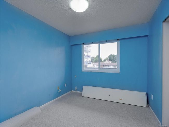 Carpeted empty room with a textured ceiling and baseboards | Image 16