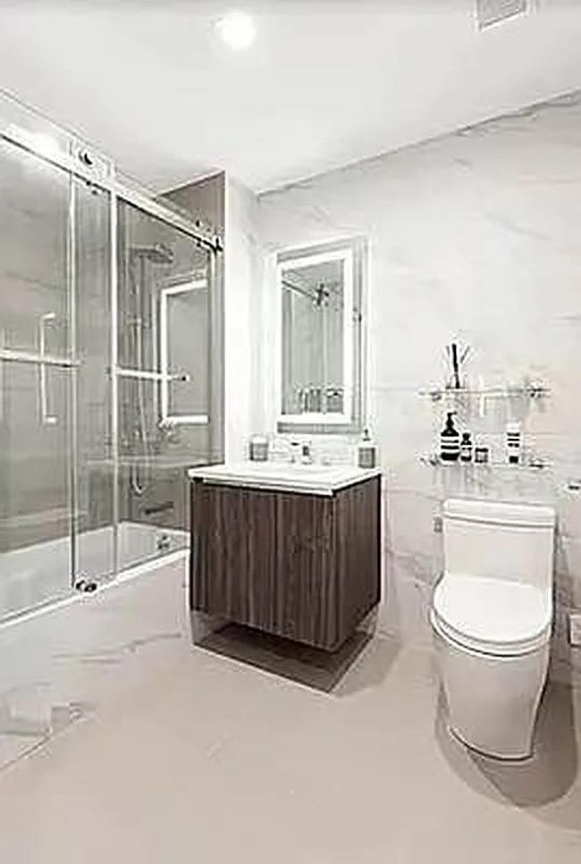 Bathroom featuring bath / shower combo with glass door, vanity, and toilet | Image 14