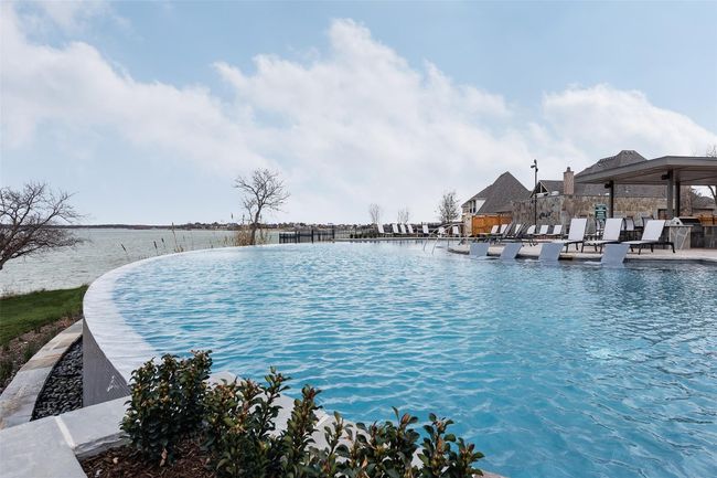 Up close view of the lakeside infinity pool with tanning ledges, waterfall overflow, outdoor grilling, fire pits and music. In the summer enjoy live music and get togethers with | Image 38