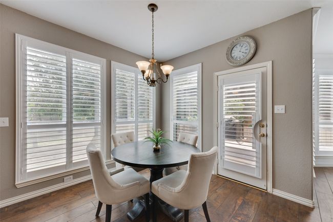 Dining room with plenty of natural light, dark wood-type flooring, a notable chandelier, and baseboards | Image 10