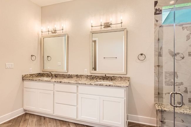 Full bathroom featuring wood finished floors, baseboards, a sink, and a stall shower | Image 20