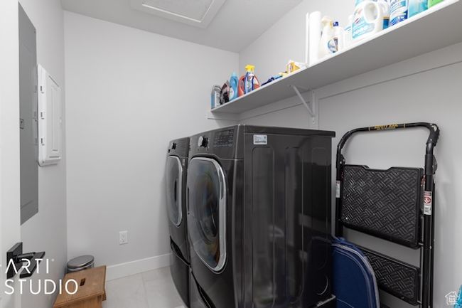 Laundry room featuring electric panel, separate washer and dryer, tile patterned flooring, baseboards, and laundry area | Image 28