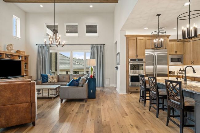 Living area with light wood-type flooring, plenty of natural light, and an inviting chandelier | Image 16