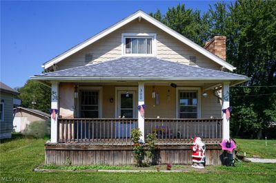 Bungalow with a porch and a front yard | Image 1