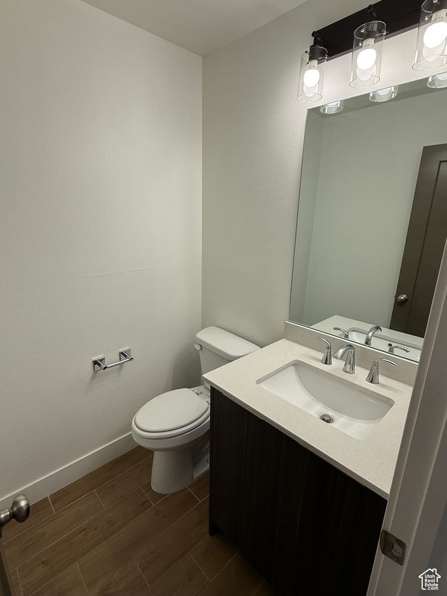Bathroom featuring vanity, baseboards, toilet, and wood finished floors | Image 13