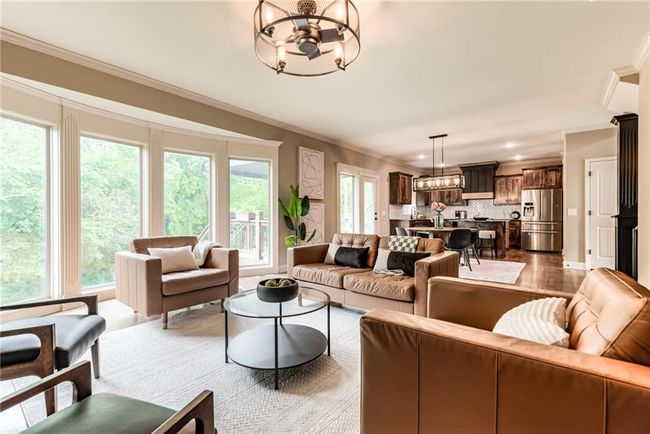 Living area featuring a chandelier, ornamental molding, wood finished floors, and recessed lighting | Image 16