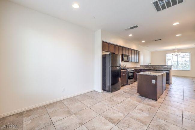 Kitchen featuring visible vents, a sink, a peninsula, and black appliances | Image 20