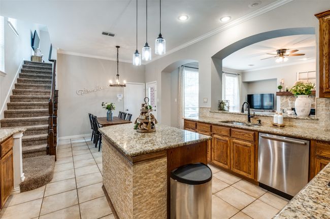 Kitchen with view to second staircase, breakfast nook and open to Family Room. Enjoy the nice island while cooking. | Image 12