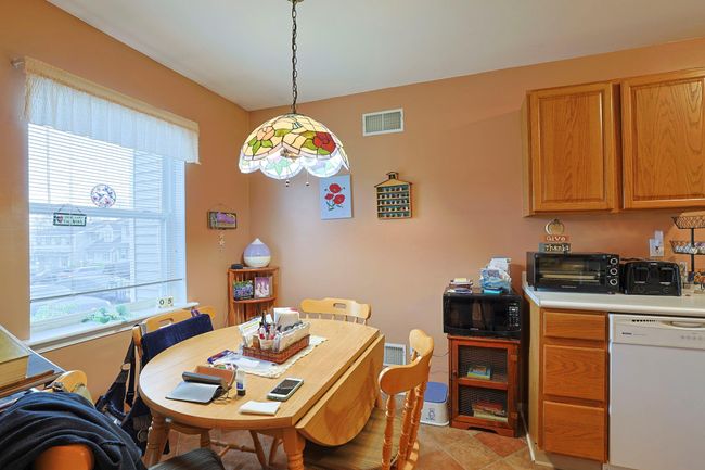 Dining room with light tile patterned floors, a toaster, and visible vents | Image 7