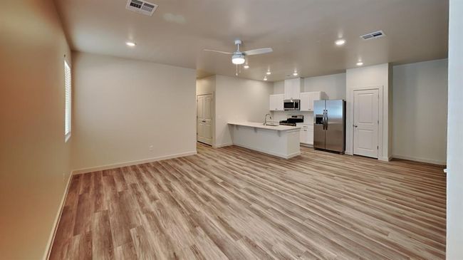 Kitchen featuring visible vents, stainless steel appliances, light countertops, and light wood-style flooring | Image 4