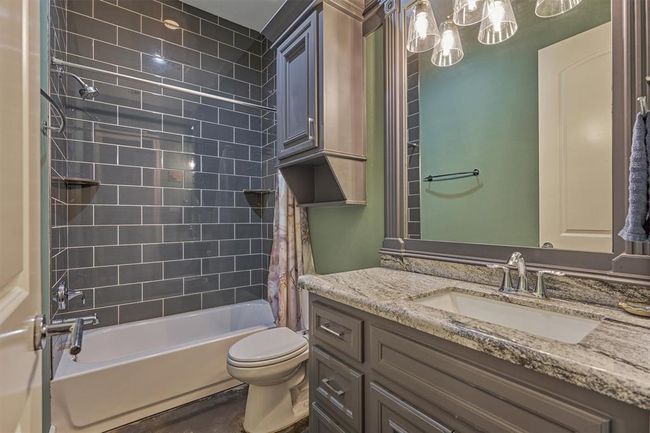 The en-suite bath for the second guest bedroom highlights the same custom millwork and high-end finishes found throughout the home, creating a cohesive and refined design. | Image 16