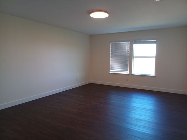 Spare room with baseboards and dark wood-style flooring | Image 27