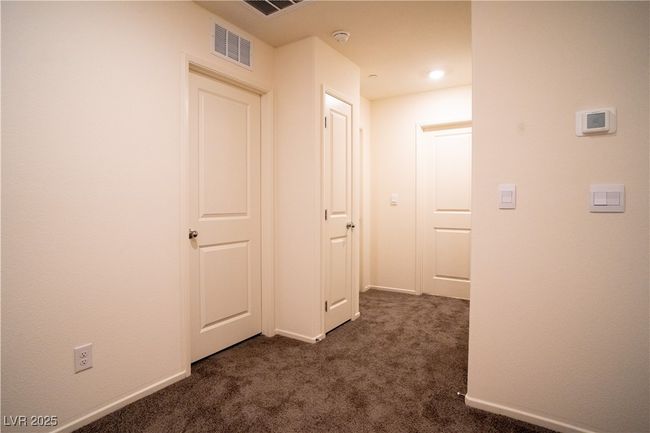 Hallway with dark carpet and baseboards | Image 10