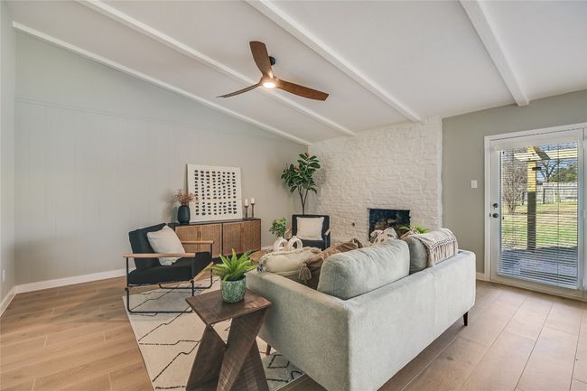 Living area with light wood-type flooring, a fireplace, and ceiling fan | Image 7
