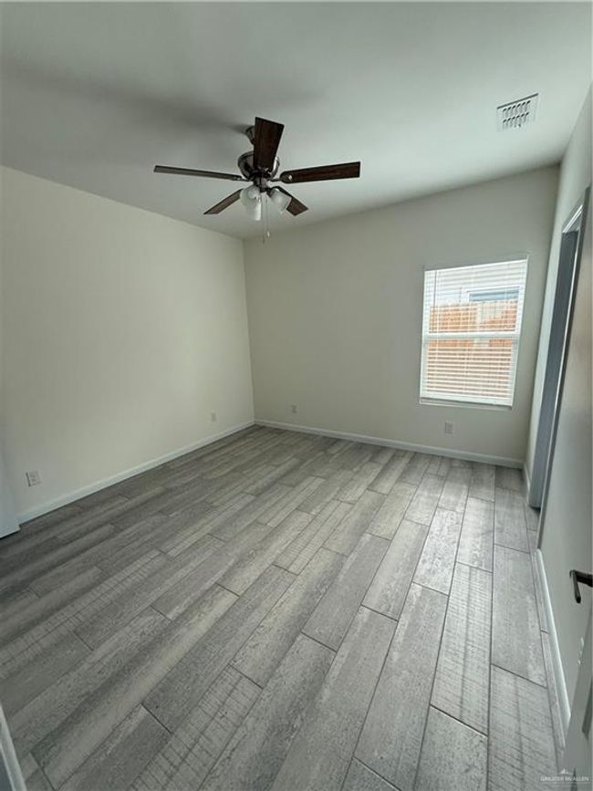 Unfurnished room featuring a ceiling fan, wood finished floors, and baseboards | Image 8