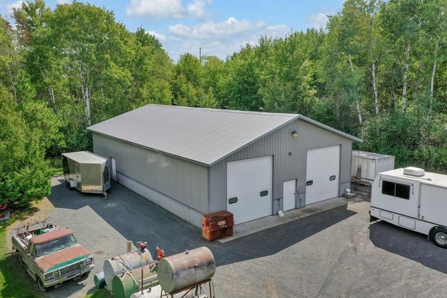 Ample firm surface parking areas around pole building and garage. Above ground fuel storage tanks will be removed. Truck body storage shed on the other side of the pole building. | Image 30