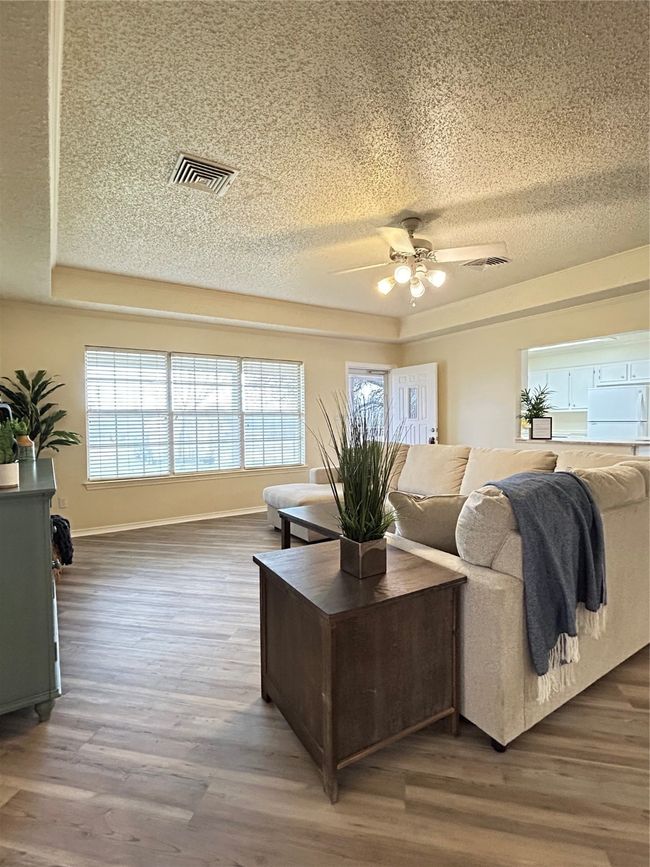 Living area with visible vents, a textured ceiling, and wood finished floors | Image 9