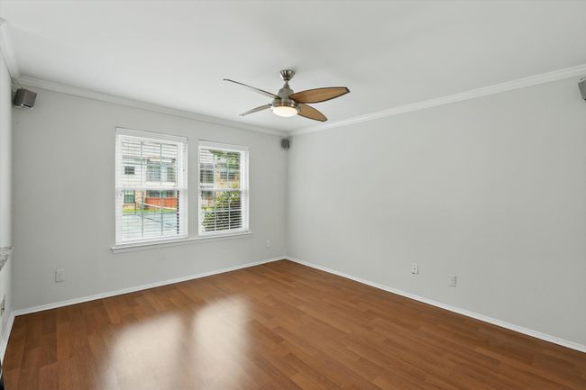 Empty room featuring ceiling fan, wood finished floors, ornamental molding, and baseboards | Image 4