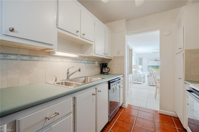 Kitchen with white cabinetry, tile flooring, electric stove, tasteful backsplash, and dishwasher | Image 14