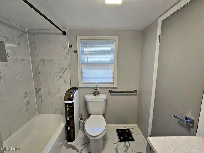 Full bath with marble finish floor, tub / shower combination, toilet, and vanity | Image 35