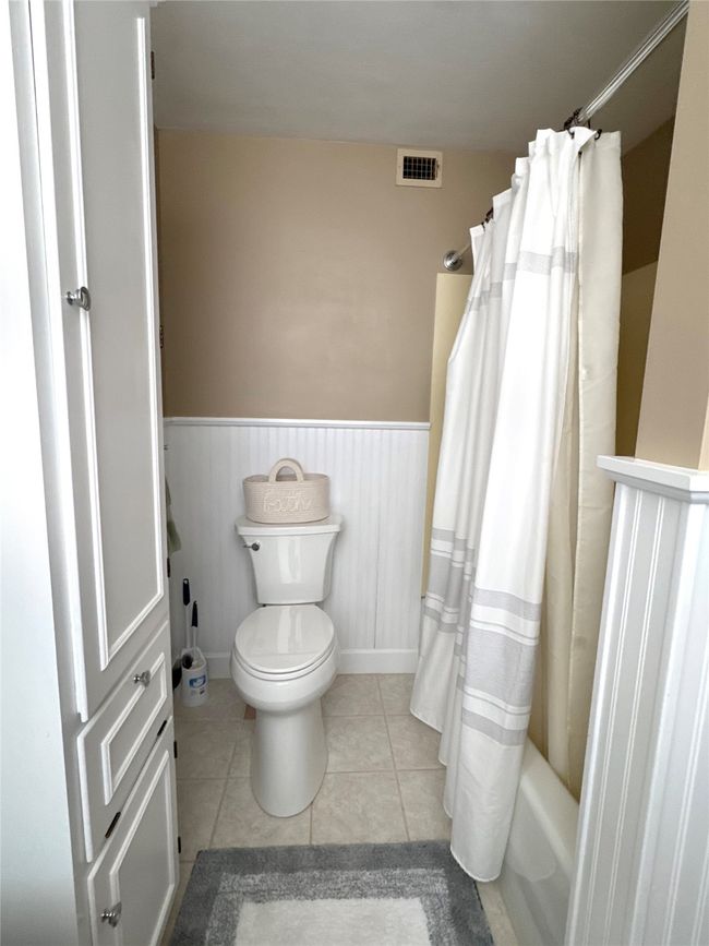 Bathroom with toilet, tile patterned flooring, and shower / bath combo | Image 35