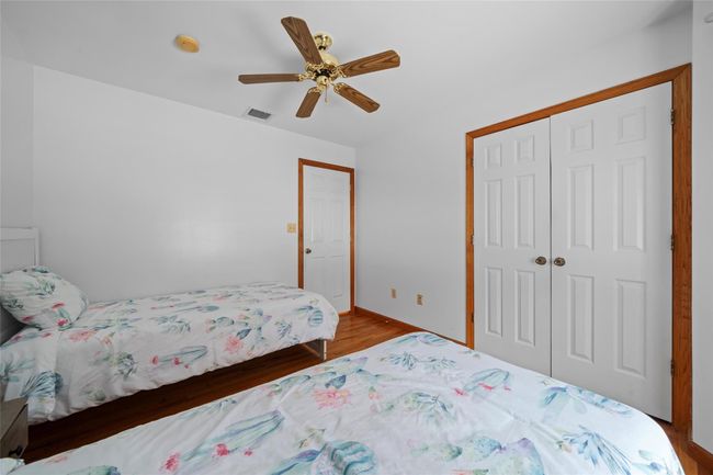 Bedroom with wood finished floors, a closet, ceiling fan, baseboards, and visible vents | Image 31