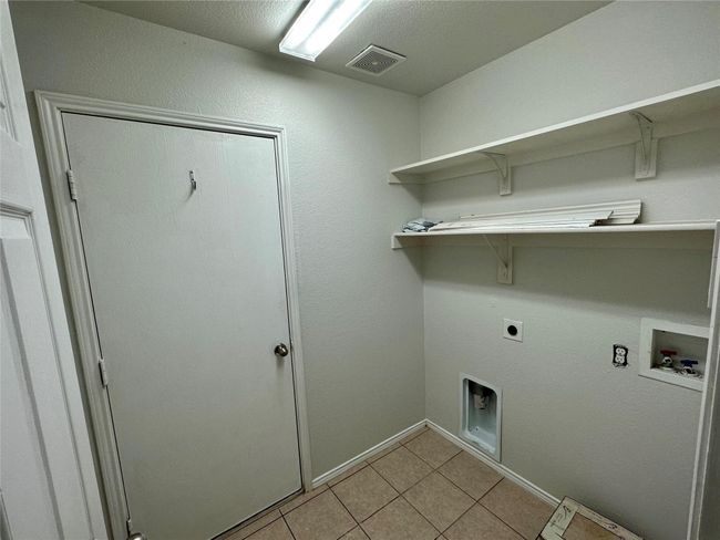 Clothes washing area with light tile patterned flooring, electric dryer hookup, laundry area, visible vents, and hookup for a washing machine | Image 14