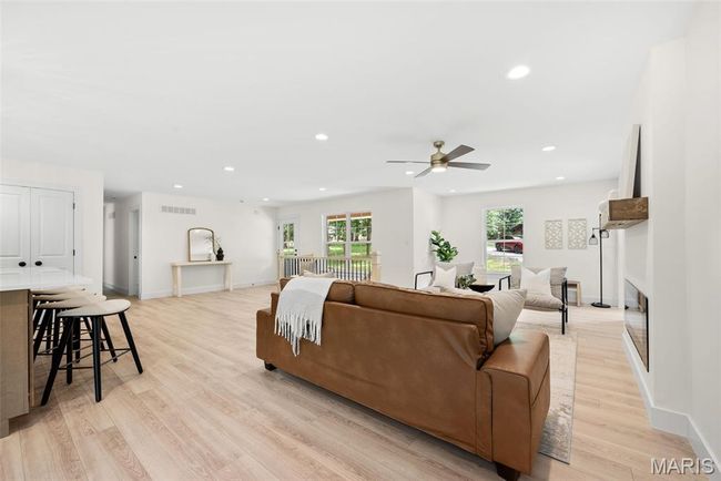 Living area with recessed lighting, light wood finished floors, a ceiling fan, and a fireplace | Image 11