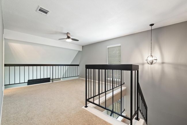Hallway with an upstairs landing, carpet floors, and baseboards | Image 19