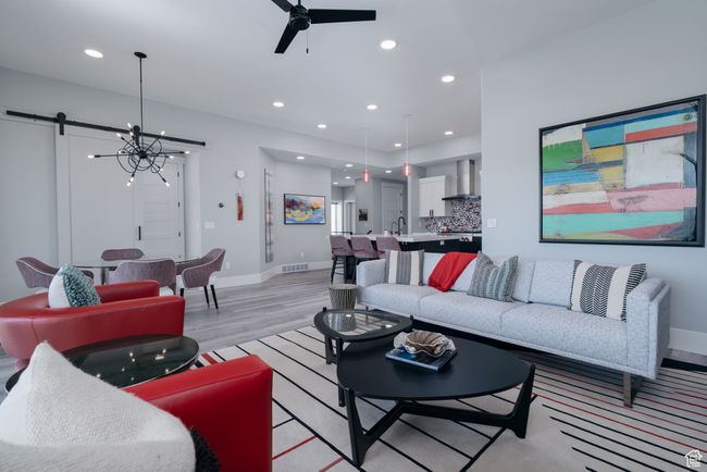 Living area featuring light wood-style floors, a ceiling fan, baseboards, recessed lighting, and a chandelier | Image 14