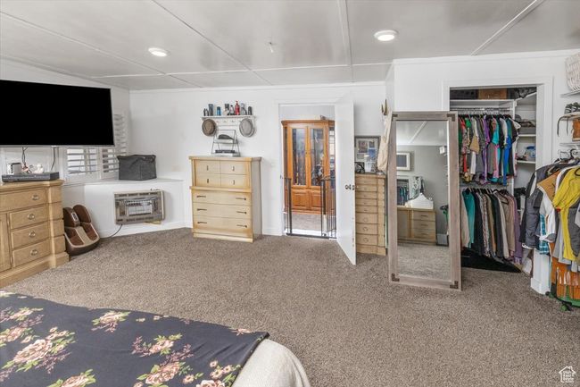 Bedroom featuring a closet, heating unit, and carpet floors | Image 20