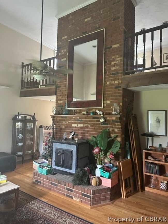 Living room with ornamental molding, brick wall, and hardwood / wood-style flooring | Image 5