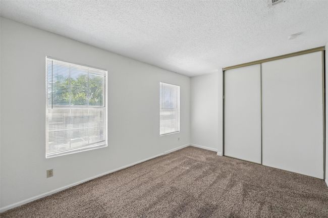 Unfurnished bedroom featuring a closet, carpet, and a textured ceiling | Image 13
