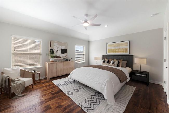 Spacious upstairs secondary bedroom featuring rich wood floors, abundant natural light, and a neutral palette—perfect for guests or family members seeking comfort and privacy. *This photo has been virtually staged.* | Image 33